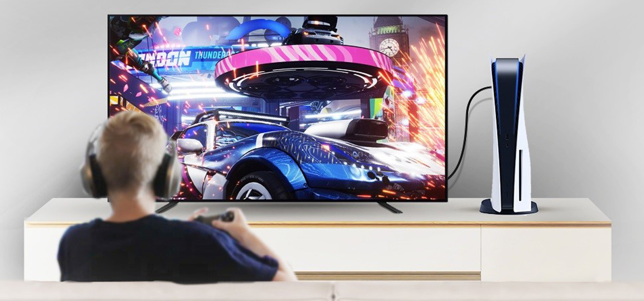 A man is playing game on TV using his controller while connection is using the 8K HDMI 2.1 Cable.
